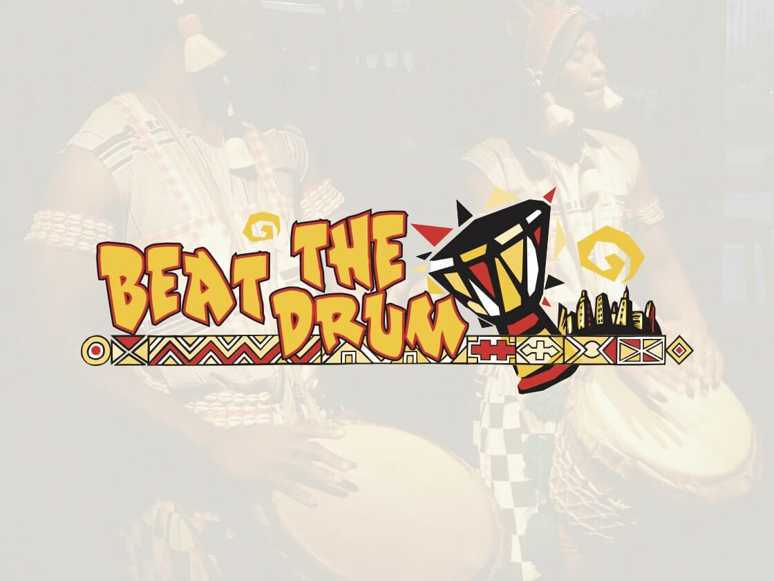 Two drummers in traditional attire are playing hand drums. The text "Beat the Drum" is prominently displayed over the image, with decorative elements including a stylized drum and abstract patterns. The background is slightly faded, making the text and designs stand out.